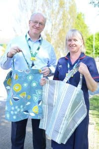 Paul Roberts and Debbie Williams holding fabric bags